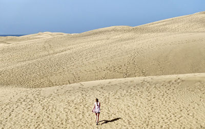 Full length of woman on desert against clear sky