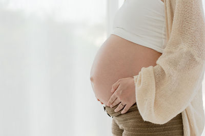 Midsection of woman standing against wall