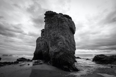 Low angle view of rock formation on beach against sky