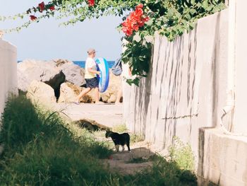 Friends sitting on plant by wall