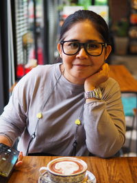 Portrait of young woman drinking coffee