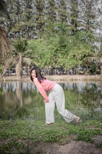 Side view of woman standing by lake