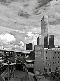 Buildings in city against cloudy sky