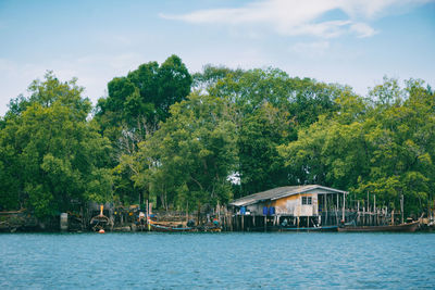 Houses by lake against sky