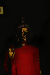 Statue of buddha against black background