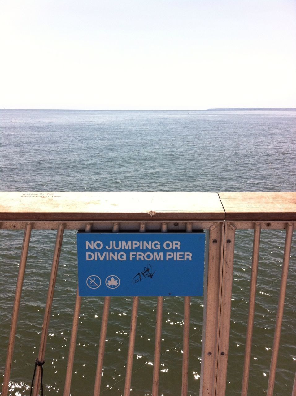 sea, water, horizon over water, text, clear sky, western script, railing, communication, tranquil scene, tranquility, copy space, nature, scenics, sky, pier, beauty in nature, transportation, day, guidance, ocean