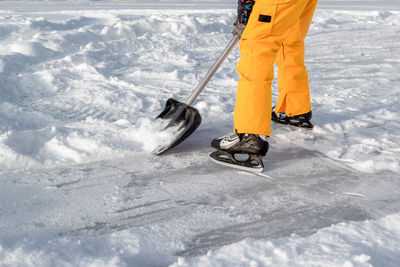 Low section of man cleaning snow