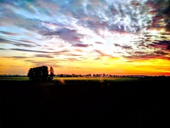 Scenic view of silhouette field against sky during sunset