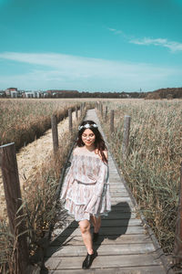 Portrait of woman standing against sky