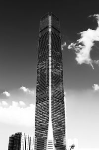 Low angle view of skyscrapers against cloudy sky