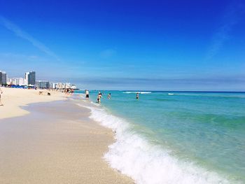 Scenic view of beach against blue sky