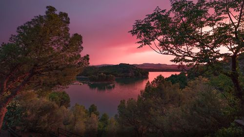 Scenic view of lake against sky at sunset