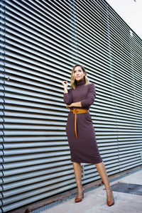 Rear view of woman standing against wall