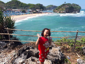 Portrait of smiling girl standing on sea shore