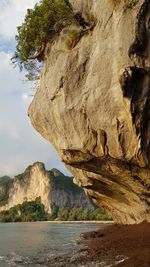 Rock formations by sea against sky