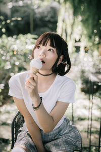 Portrait of beautiful woman standing against plants