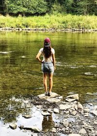 Rear view of woman standing in lake