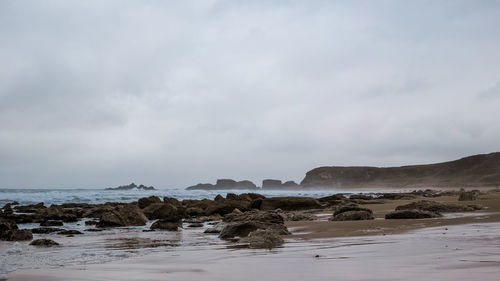 Rocks on beach against sky