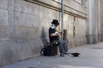 Man sitting on floor in city