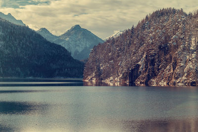 Scenic view of lake by mountains against sky