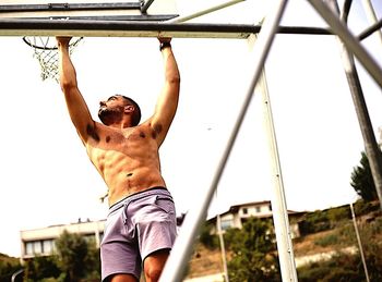 Low section of young man hanging on clothesline