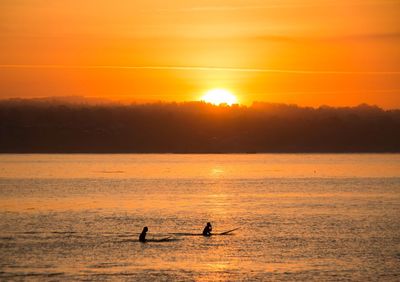 Scenic view of sea against orange sky during sunset