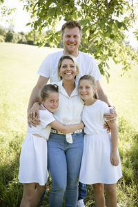 Portrait of smiling family standing on field