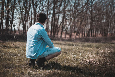 Full length of man crouching on field