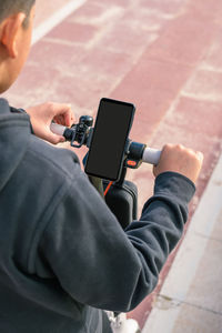 Young man on an electric scooter using smartphone gps applications