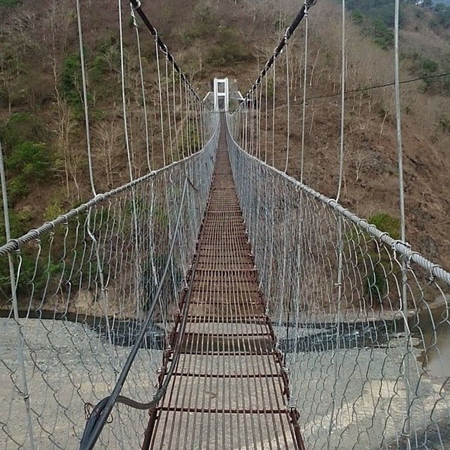 the way forward, railing, connection, diminishing perspective, metal, footbridge, bridge - man made structure, vanishing point, transportation, built structure, day, long, outdoors, fence, no people, high angle view, chainlink fence, architecture, walkway, sunlight