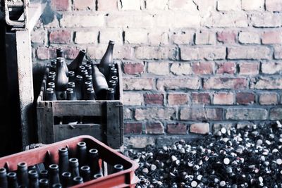 High angle view of wine bottles by brick wall