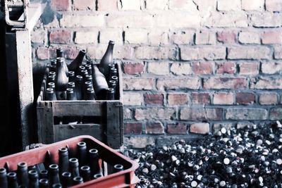 High angle view of wine bottles by brick wall