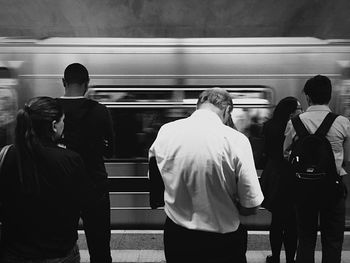 Rear view of people on station platform.