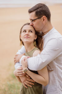 Side view of couple embracing outdoors