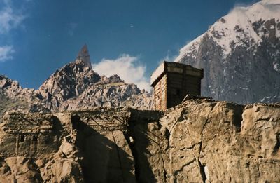 Low angle view of rocks and mountains with 
 a fort against sky