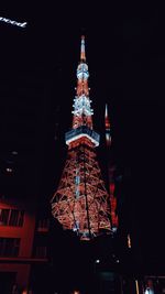 Low angle view of illuminated buildings against sky at night