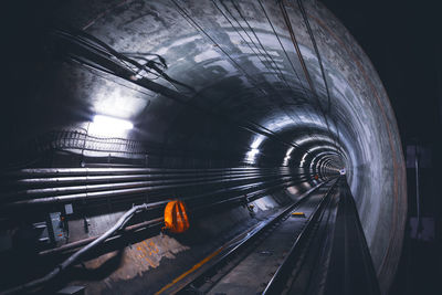 Railroad tracks in illuminated tunnel