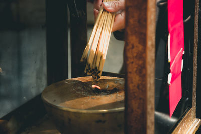 Close-up of person burning incense sticks