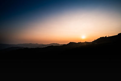 Scenic view of silhouette mountains against sky during sunset