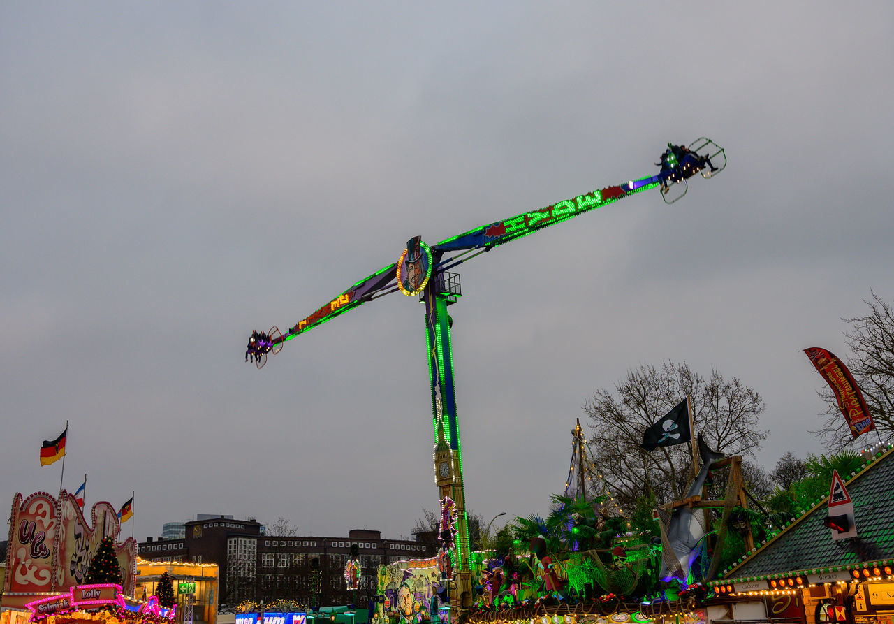 architecture, amusement park, sky, nature, arts culture and entertainment, amusement park ride, park, amusement ride, machinery, city, built structure, outdoors, event, multi colored, celebration, crane - construction machinery, tree, building exterior, travel destinations, no people, roller coaster