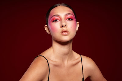 Portrait of young woman against black background