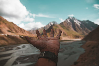 Midsection of person with mountain in background