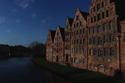 View of canal by buildings against sky