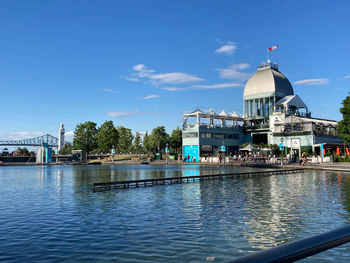 View of building by canal against sky in city