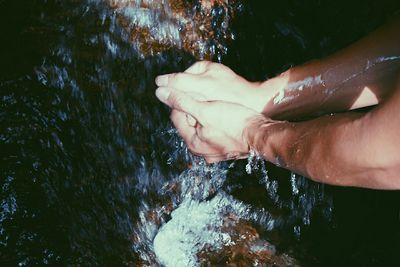 Low section of man swimming in river