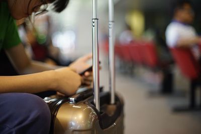 Close-up of woman holding mobile phone in bus