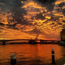 Scenic view of sea against cloudy sky at sunset