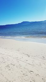 Scenic view of beach against clear blue sky