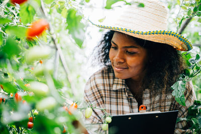 Young woman using laptop while sitting on field