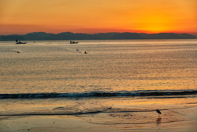 Scenic view of sea against orange sky